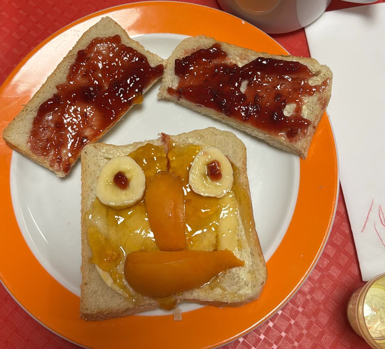 Toast, aus Pfirsich und Banane zu einem Gesicht belegt