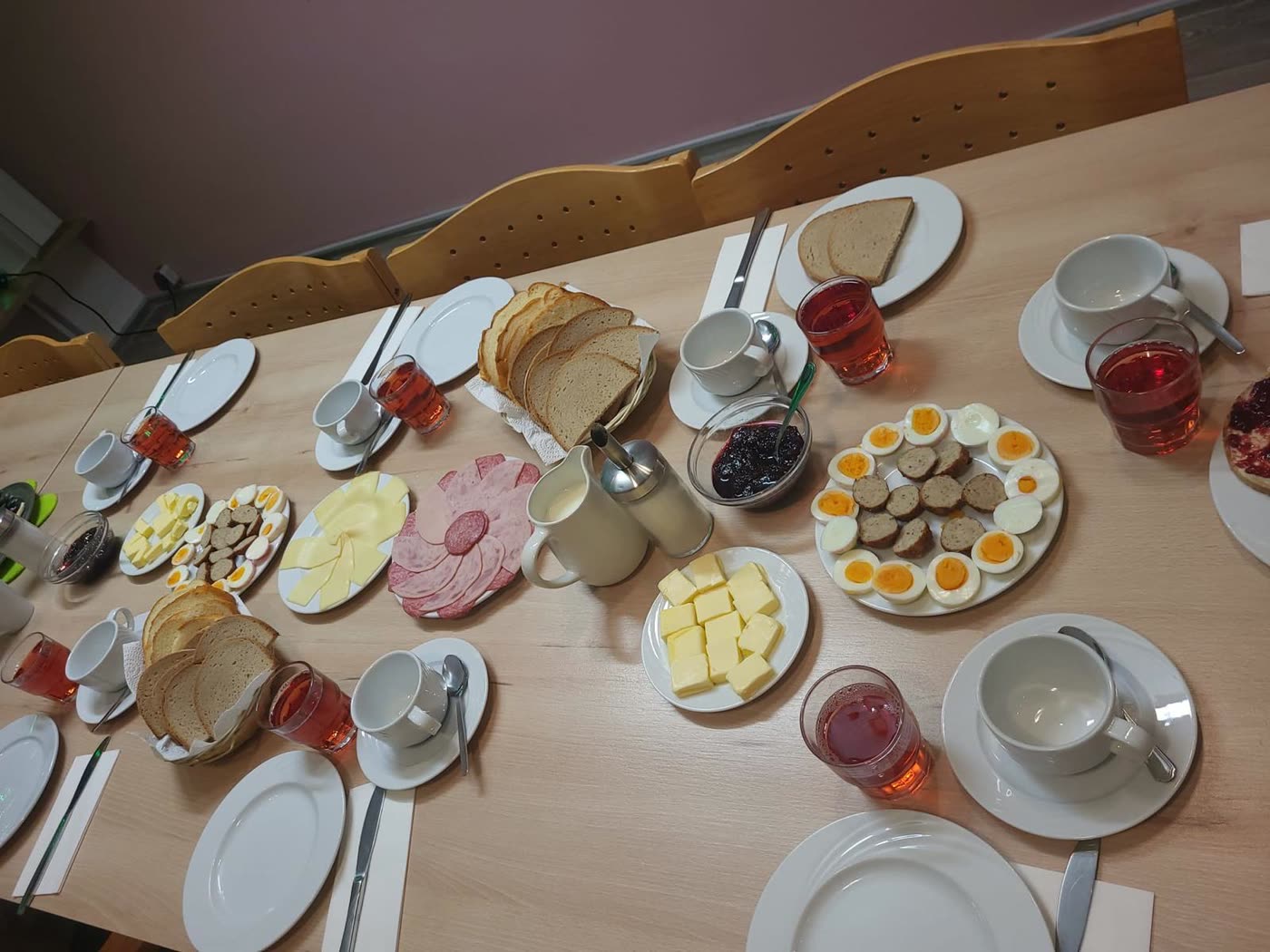 Lange Tafel in der Wohnküche mit vielen Platten und Gedecken