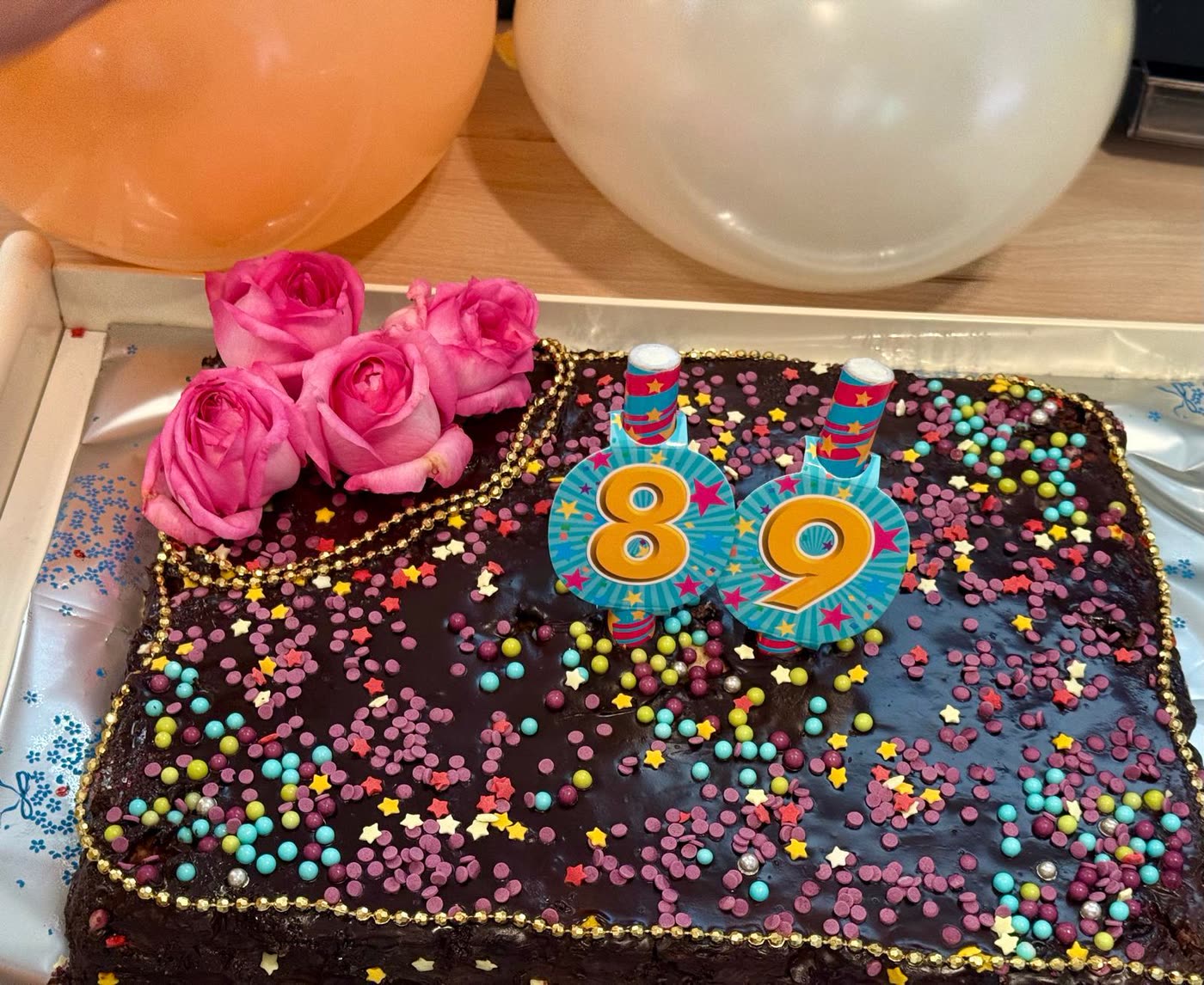 Schokoladentorte mit bunten Streuseln, Rosen und den Kerzen 8 und 9